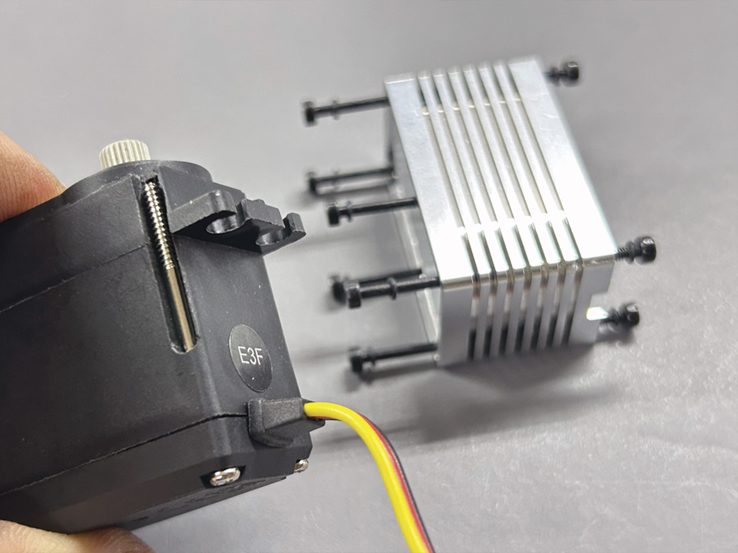 Close up of a cheaply made servo case where the assembly relies on four coarse thread screws in plastic