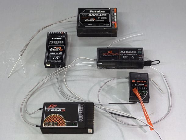 A shot of several brands of consumer-brand RC model receivers against a gray background